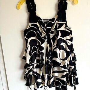 Bosom flattering black & white print blouse w/ faux leather straps. Ties in back